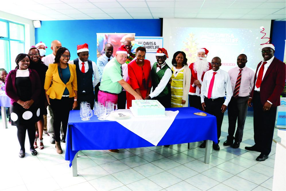 Chairman Alec Davis and David Gatende cutting the christmas cake with other members of staff